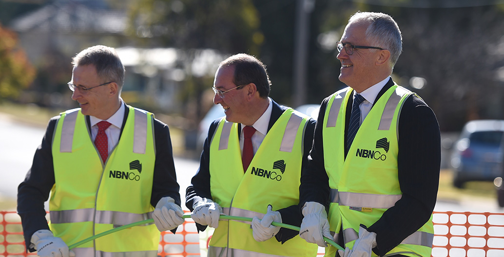 Then-Federal Minister for Communications Malcolm Turnbull (right) lends a hand rolling out NBN fibre during a visit to an NBN rollout site in Queanbeyan, near Canberra, Wednesday, June 3, 2015. AAP Image/Lukas Coch