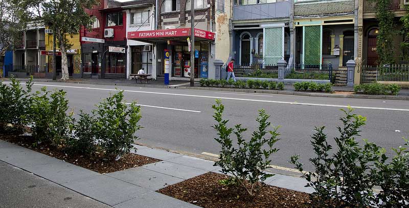 The hedges have been set back from the kerb with regular breaks in the hedging to let people access parked cars from the footpath.