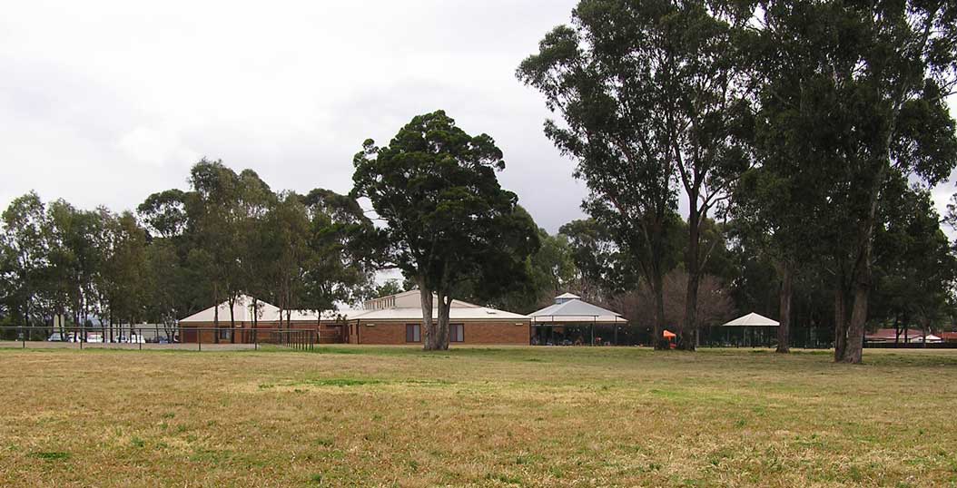 An after school centre fenced behind quite open fields.