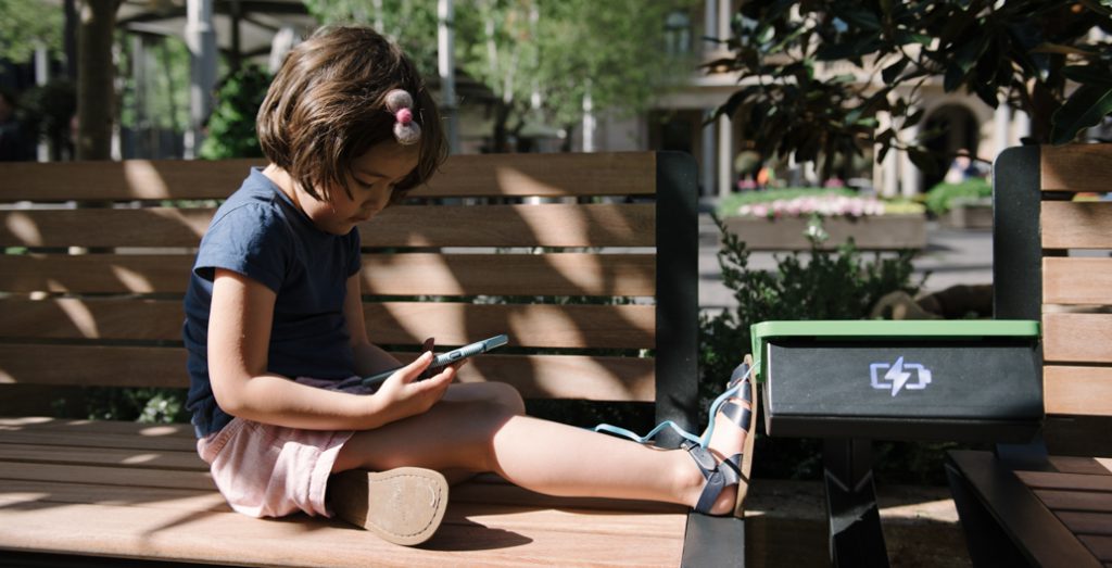 A digi-native takes a liking to a phone-charging bench in public space. Image: WE-EF.