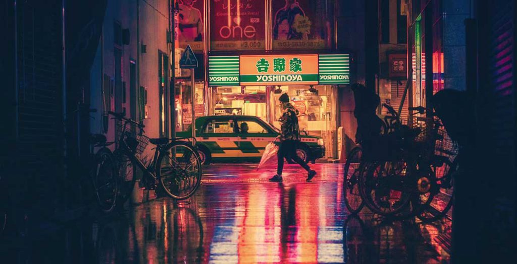 A woman walking in a night street in Japan.