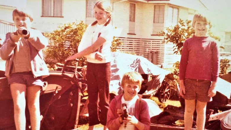 Walsh was brought up in Townsville, with a free-form yard. Here playing in 'Dad’s vintage car collection'.