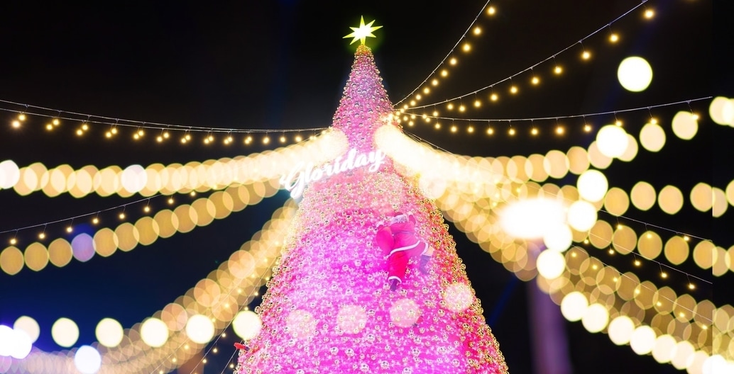 Tapering cone-shape, sheathed with light; star above; gifts in a circle around its base. Taiwan shopping Mall tree.