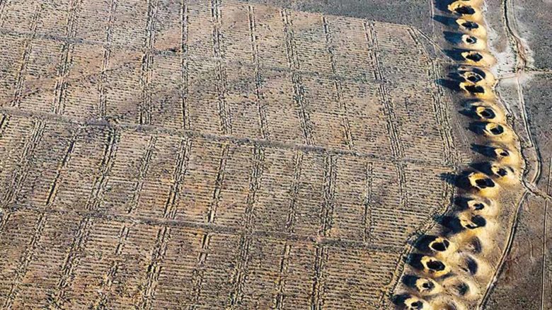 A line of evenly spaced spoil craters in Iraq is the only evidence of a subterranean man-made water stream called a qanat, first constructed by the Persians during the early years of the first millennium BCE. Photo: © Alireza Teimoury