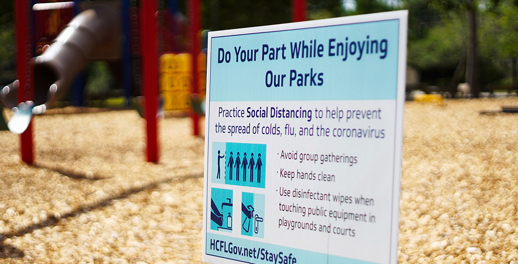 Signage in public parks in Florida encourages distance between people. Image: Jordan Hopkins