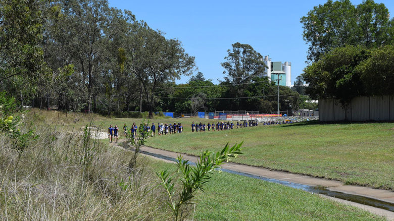 Students from a nearby school walk Small Creek's old concrete channel. Image: Courtesy Amalie Wright