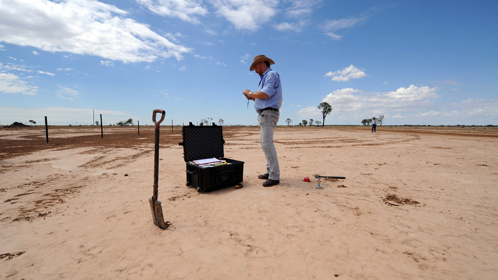 Regenerative farmer Ray Thompson standing on a salt scald on a farm in New South Wales.