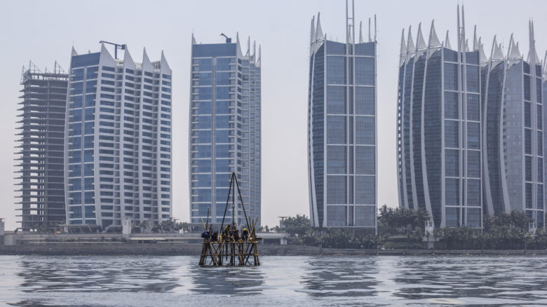 Workers on a bamboo platform take sea floor measurements of Jakarta Bay in front of the massive Regata Development Complex in North Jakarta.